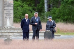FILE - Britain's Queen Elizabeth II and The Duke of Edinburg, Prince Philip (L), are show the memorial site of former Nazi concentration camp Bergen-Belsen by memorial site director Jens-Christian Wagner (C), on June 26, 2015.
