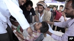 Medics and other men carry an injured tribesman loyal to tribal leader Shiekh Sadiq al-Ahmar after clashes with police forces outside al-Ahmar's house in Sanaa, May 31, 2011