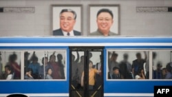 Portreti severnokorejskih lidera Kim Il Sunga i Kim Džong Ila. (Foto: AFP/Ed Jones)