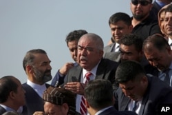 FILE - Abdul Rashid Dostum, center, a former warlord and Afghanistan's vice president at the time, disembarks with members of his entourage from his plane on arrival at Kabul International Airport, in Kabul, Afghanistan, July 22, 2018.
