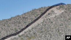 A rugged uphill section of the international border wall that runs through Organ Pipe National Monument is shown, Aug. 22, 2019 in Lukeville, Ariz. Construction on a 2 mile portion of replacement fencing has begun near the official border crossing.