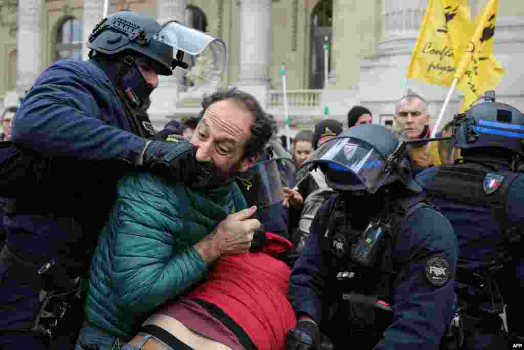 A protester bites the hand of a police officer in riot gear during a demonstration called by the French Farmers&#39; Confederation union to protest against the inauguration of the 64th edition of the European Commodities Exchange at the Grand Palais, in Paris, France.