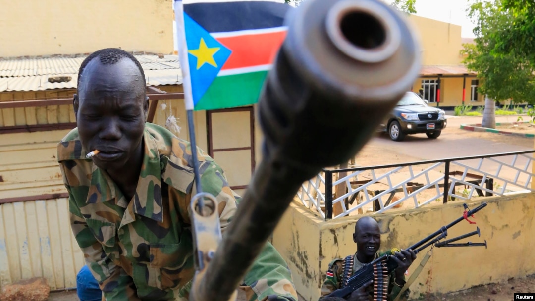 A South Sudan army soldier stands next to a machine gun mounted on a truck in Malakal, capital of Upper Nile state, which an official says is controlled by forces loyal to former Vice President Riek Machar. 