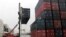 FILE - Workers load containers onto trucks from a cargo ship at a port in Jaragua do Sul, Santa Catarina state, Brazil, Oct. 22, 2015. 