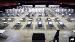 FILE - A worker moves items at a Federal Medical Station for hospital surge capacity set up at Temple University's Liacouras Center in Philadelphia, March 30, 2020.