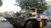 Seorang biksu Buddha memegang tanda berdiri di samping kendaraan lapis baja selama protes terhadap kudeta militer, di Yangon, Myanmar, 14 Februari 2021. (Foto: Reuters)