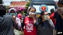 Warga mengenakan masker ketika berusaha mengidentifikasi mayat keluarga mereka di RS polisi di Palu, 30 September 2018.