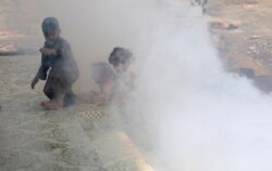 FILE - Children are seen amidst smoke from fumigation at a market during a fumigation campaign while the spread of the coronavirus disease (COVID-19) continues), on the outskirts of Sanaa, Yemen, April 13, 2020.