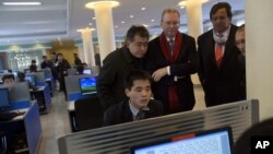 Executive Chairman of Google, Eric Schmidt (C) and former New Mexico governor Bill Richardson (2nd R) watch as a North Korean student surfs the Internet at a computer lab during a tour of Kim Il Sung University in Pyongyang, January 8, 2013. 