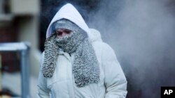 A commuter walks along Market Street in freezing temperatures Tuesday, Nov. 18, 2014, in Philadelphia, Pennsylvania.