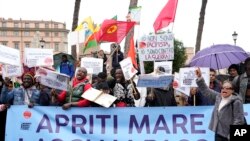 FILE - Migrants associations members show a banner reading "Sea, open and let them pass" during a protest against Italy's government's migrants' policy in Rome, April 18, 2023