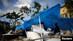 Joe Quirindongo tries to repair a makeshift tent where he keeps some belongings at the squatter community of Villa Hugo in Canovanas, Puerto Rico, Dec. 9, 2017. Villa Hugo is a settlement initially formed by people whose houses were damaged or destroyed by Hurricane Hugo in 1989.