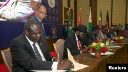 Le chef des rebelles sud-soudanais, Riek Machar et le président du Soudan du Sud, Salva Kiir, lors de la signature du dernier accord de cessez-le-feu et de partage des pouvoirs à Khartoum, au Soudan, le 5 août 2018.