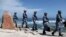 FILE - Soldiers of China's People's Liberation Army (PLA) Navy patrol at Woody Island, in the Paracel Archipelago, which is known in China as the Xisha Islands, Jan. 29, 2016. China has stepped up efforts to defend its sovereignty claims in the disputed South China Sea by launching a week-long military drill around the Paracel Islands.