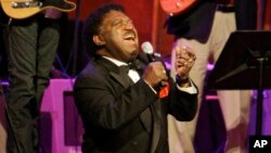 FILE - Percy Sledge kneels as he performs "When a Man Loves a Woman" along with the Muscle Shoals Rhythm Section at the Musicians Hall of Fame awards show in Nashville, Tennessee, Oct. 28, 2008.