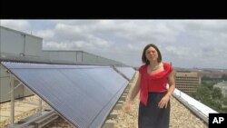 Meghan Chapple-Brown, director of Sustainability, stands by some of the solar hot-water systems that are on the rooftops of several buildings at George Washington University in urban Washington, D.C., June 2011