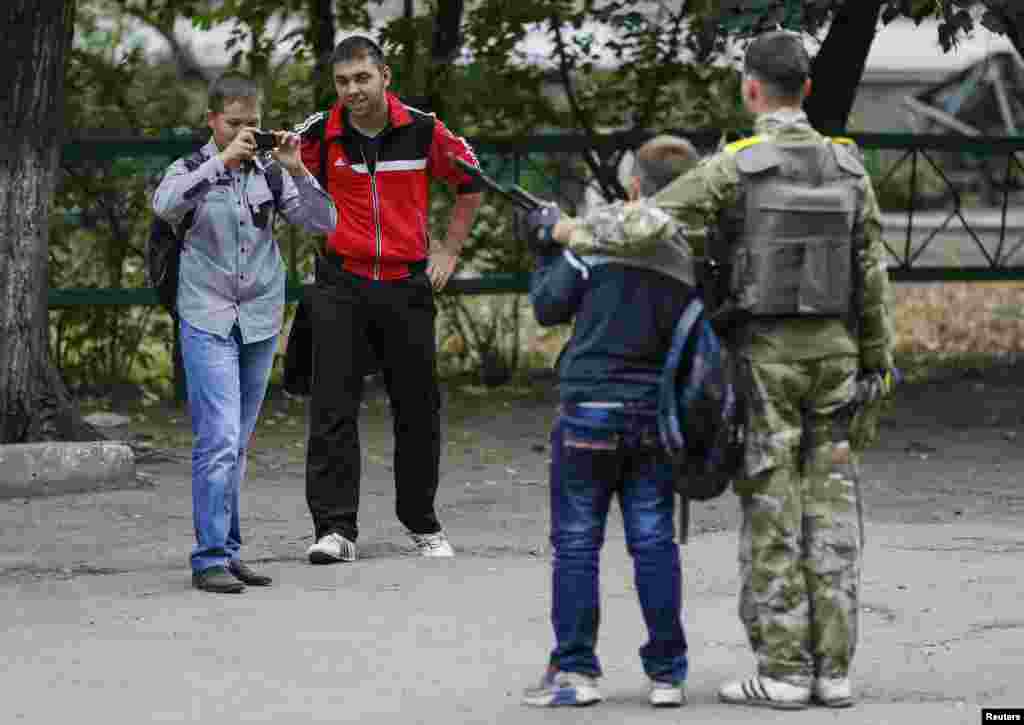 A boy poses for a picture with a Ukrainian serviceman in central Slovyansk, Sept. 9, 2014.