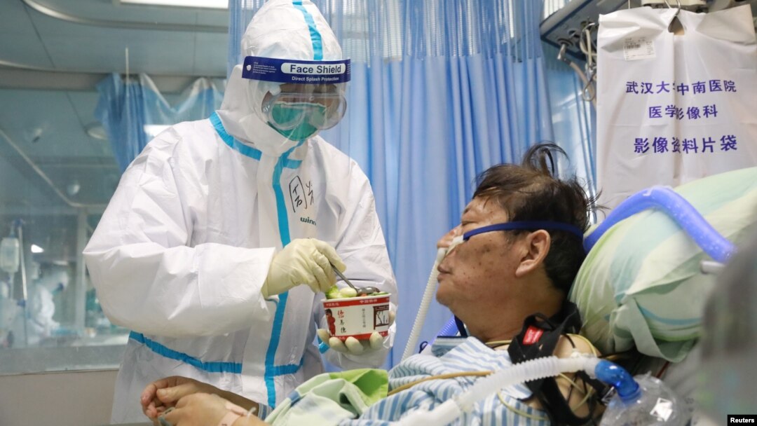 A nurse in a protective suit feeds a novel coronavirus patient inside an isolated ward at Zhongnan Hospital of Wuhan University, during the Lantern Festival, which marks the end of the Chinese Lunar New Year celebrations, in Wuhan, Hubei province.