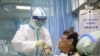 A nurse in a protective suit feeds a novel coronavirus patient inside an isolated ward at Zhongnan Hospital of Wuhan University, during the Lantern Festival, which marks the end of the Chinese Lunar New Year celebrations, in Wuhan, China, Feb. 8, 2020.