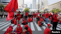 Para pekerja beristirahat di sela pawai Hari Buruh (May Day) di Jakarta, Indonesia, 1 Mei 2018. (Foto: REUTERS/Beawiharta)