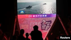 Layar raksasa menampilkan cuplikan berita latihan militer di Selat Taiwan serta wilayah utara, selatan, dan timur Taiwan, oleh Komando Teater Timur Tentara Pembebasan Rakyat China (PLA), di Beijing, China, 14 Oktober 2024. (Foto: Tingshu Wang/Reuters)