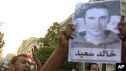 Protesters chant slogans and hold pictures of Khaled Said, as they rally in memory of him outside the Interior Ministry in Cairo, Jun 6, 2011