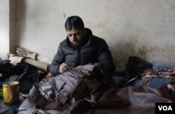 Mushtaq Ahmed prepares orders for his clients who visit different parts of India during winter to sell leather items such as jackets, gloves and socks, near Srinigar, Indian-administered Kashmir, on Dec. 18, 2024. (Wasim Nabi for VOA)