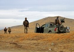 Afghan security forces keep watch outside of a military compound after a car bomb blast on the outskirts of Ghazni city, Afghanistan, Nov. 29, 2020.