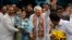 Congress party leader Kapil Sibal, center and his wife Promila Sibal flash victory signs as supporters present them with flower bouquets after Sibal filed his nomination papers for the upcoming parliamentary elections in New Delhi, India, March 20, 2014.