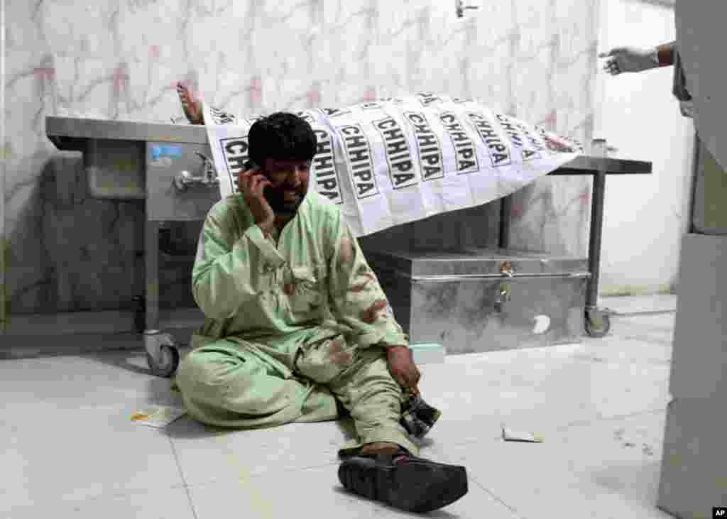 A man talks on his phone at a hospital in Quetta, Pakistan, after a roadside bomb struck a security vehicle, killing at least four people.