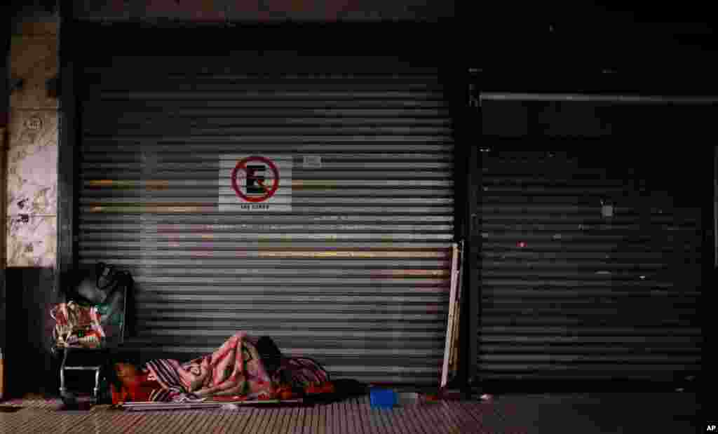 یک بی خانمان در خیابانی در بوینس آیرس آرژانتین. برای جلوگیری از شیوع کرونا دولت آرژانتین دستور تعطیلی شبانه را صادر کرده است.