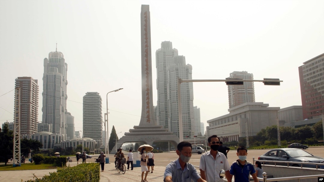 FILE - People wearing masks make their way in the Ryomyong street in Pyongyang, North Korea, July 3, 2020. 