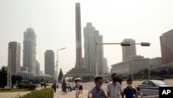 People wearing masks make their way in the Ryomyong street in Pyongyang, North Korea, July 3, 2020. 