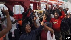 Migrants lift up Basile Fischer, SOS Mediterranee's deputy search and rescue coordinator, during a celebration aboard the Ocean Viking in the Mediterranean Sea, Sept. 23, 2019. 