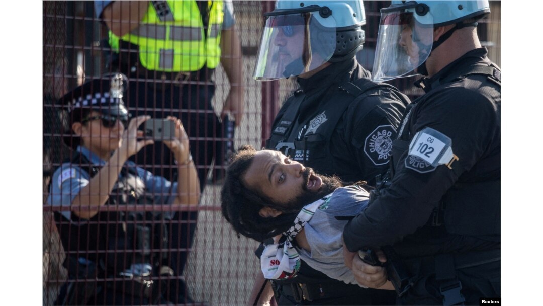 Policija privodi čovjeka nakon što je nekoliko demonstranata probilo bezbjednosnu ogradu. (Foto: REUTERS/Adrees Latif)