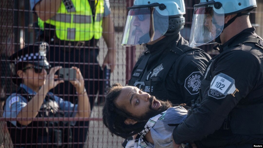 Policija privodi čoveka nakon što je nekoliko demonstranata probilo bezbednosnu ogradu u (Foto: REUTERS/Adrees Latif)