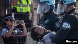 Policija privodi čoveka nakon što je nekoliko demonstranata probilo bezbednosnu ogradu u (Foto: REUTERS/Adrees Latif)