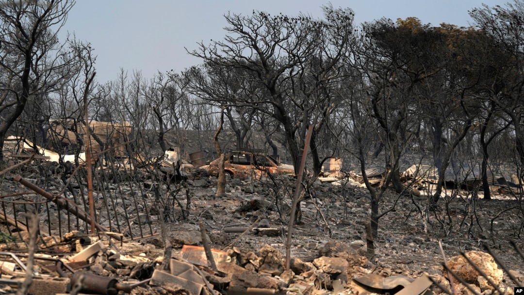 ARCHIVO - Esta fotografía del 19 de julio de 2023 muestra árboles quemados y un vehículo calcinado después de un incendio forestal, en Mandra, al oeste de Atenas.