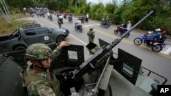 ARCHIVO - Soldados vigilan una carretera en Tarazá, Colombia, el miércoles 15 de marzo de 2023. 