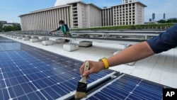 Workers clean solar panels that provide partial electrical power to Istiqlal Mosque in Jakarta, Indonesia, March 29, 2023.