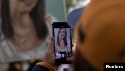 Un manifestante venezolano toma una foto de un retrato de María Corina Machado en Santiago de Chile, el 28 de septiembre de 2024.