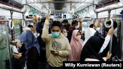 Penumpang yang memakai masker pelindung berdiri di dalam kereta komuter pada jam sibuk sore hari saat varian omicron terus menyebar, di tengah pandemi COVID-19, di Jakarta, 3 Januari 2022. (Foto: REUTERS/Willy Kurniawan)