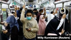 Penumpang yang memakai masker pelindung berdiri di dalam kereta komuter pada jam sibuk sore hari saat varian omicron terus menyebar, di tengah pandemi COVID-19, di Jakarta, 3 Januari 2022. (Foto: REUTERS/Willy Kurniawan)