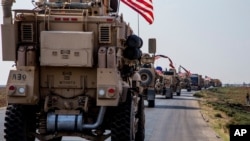FILE - U.S. military convoy drives near the town of Qamishli, northern Syria, Oct. 26. 2019. 