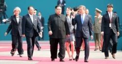 FILE - South Korean President Moon Jae-in and North Korean leader Kim Jong Un arrive at the Peace House in the truce village of Panmunjom inside the demilitarized zone separating the two Koreas, South Korea, April 27, 2018.