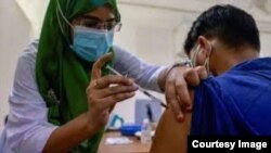 করোনার দ্বিতীয় ডোজের টিকা প্রদান শুরু হবার পর এক ব্যক্তিকে টিকা দিচ্ছেন নার্স। 