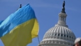 乌克兰支持者2024年4月23日在美国国会大楼外摇旗敦促国会通过950亿美元外援方案。（法新社）