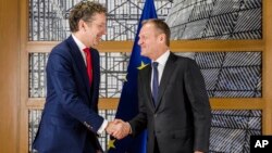 European Council President Donald Tusk, right, shakes hands with the chair of the Eurogroup Jeroen Dijsselbloem ahead of a meeting of eurozone finance ministers at the Europa building in Brussels on Dec. 4, 2017.