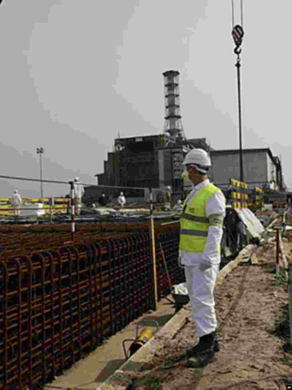 A plant worker monitors preparation of rebar cages that will used for lifting tower foundations. The lifting towers setting on these foundations will raise the arch during erection, (VOA - D. Markosian, April 2011)