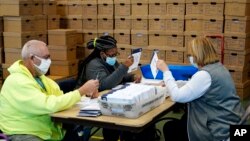 Chester County, Pa., election workers process mail-in and absentee ballots for the 2020 general election in the United States at West Chester University, Wednesday, Nov. 4, 2020, in West Chester., Pa. (AP Photo/Matt Slocum)